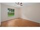 Empty bedroom with hardwood floors and a large window with a backyard view at 11648 Grand Bay Blvd, Clermont, FL 34711