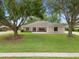 Charming single-story home with manicured front lawn and mature trees at 11648 Grand Bay Blvd, Clermont, FL 34711