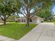 Charming single-story home with a well-maintained lawn and mature trees at 11648 Grand Bay Blvd, Clermont, FL 34711