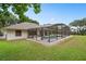 Screened pool area with home exterior and green backyard at 11648 Grand Bay Blvd, Clermont, FL 34711