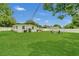 Large backyard with green lawn, white fence, and seating area, offering ample space for outdoor enjoyment and activities at 1208 Baltimore Dr, Orlando, FL 32810