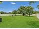 Beautifully manicured backyard featuring lush lawn, mature trees, and cozy seating area, perfect for relaxing and entertaining at 1208 Baltimore Dr, Orlando, FL 32810