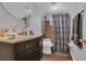 Cozy bathroom features a vanity with granite countertop, toilet and shower with patterned shower curtains at 1208 Baltimore Dr, Orlando, FL 32810