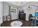 This bedroom has wood floors, a mounted TV on the dresser, a desk, and large windows at 1208 Baltimore Dr, Orlando, FL 32810