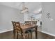 Open dining space with wooden table set for six, and a view of the updated kitchen at 1208 Baltimore Dr, Orlando, FL 32810