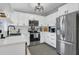 Updated kitchen features white cabinets, stainless steel appliances, and a modern subway tile backsplash at 1208 Baltimore Dr, Orlando, FL 32810
