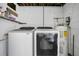 Functional laundry room with modern washer and dryer units, shelf space, and a water heater at 1208 Baltimore Dr, Orlando, FL 32810