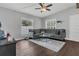 Inviting living room with a comfortable gray sofa, modern ceiling fan, and bright natural light at 1208 Baltimore Dr, Orlando, FL 32810