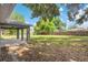 Expansive backyard with mature trees and a covered patio, offering ample space for recreation and enjoyment at 122 Seville Rd, Auburndale, FL 33823