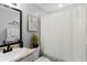 Modern bathroom with framed mirror, vanity, art, and shower with white curtain at 122 Seville Rd, Auburndale, FL 33823