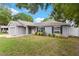 Beautiful single-story home boasts manicured landscaping, a white front door, and neutral gray paint at 122 Seville Rd, Auburndale, FL 33823