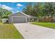 The lovely gray home features an extra long driveway, well maintained lawn, and mature trees at 122 Seville Rd, Auburndale, FL 33823