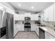 Bright kitchen featuring stainless steel appliances, white cabinets, and granite countertops perfect for cooking at 122 Seville Rd, Auburndale, FL 33823
