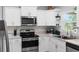 Well-equipped kitchen featuring stainless steel appliances, crisp white cabinets, and plenty of counter space at 122 Seville Rd, Auburndale, FL 33823
