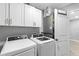 Laundry room featuring a modern washer and dryer, and storage cabinets at 122 Seville Rd, Auburndale, FL 33823