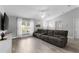 This spacious living room has a large sectional, light gray walls, wood-look flooring and a ceiling fan at 122 Seville Rd, Auburndale, FL 33823