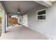 Covered back patio area with a ceiling fan, view to fenced back yard at 122 Seville Rd, Auburndale, FL 33823
