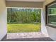 Covered back porch overlooks a well-maintained lawn and lush green space with tall trees at 1249 Champions Dr, Daytona Beach, FL 32124