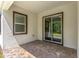 A covered back porch features a sliding glass door and a window, with brick flooring at 1249 Champions Dr, Daytona Beach, FL 32124