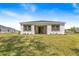 A well manicured backyard features lush lawn and a covered patio accessible through a sliding glass door at 1249 Champions Dr, Daytona Beach, FL 32124