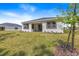 A well manicured backyard features lush lawn and a covered patio surrounded by greenery at 1249 Champions Dr, Daytona Beach, FL 32124