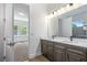 Bathroom features a double vanity with a large mirror and access to a bedroom with abundant natural light at 1249 Champions Dr, Daytona Beach, FL 32124