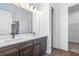 Bathroom with dual sinks, large mirror and tiled walk-in shower at 1249 Champions Dr, Daytona Beach, FL 32124