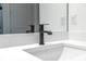 Modern bathroom features a sleek, matte-black faucet set against a white quartz countertop at 1249 Champions Dr, Daytona Beach, FL 32124