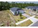 New construction shows a single-story home with brick driveway and lawn on a sunny day at 1249 Champions Dr, Daytona Beach, FL 32124