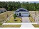 An aerial view captures the home's exterior, highlighting the paved driveway and well-maintained landscaping at 1249 Champions Dr, Daytona Beach, FL 32124