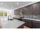 Modern kitchen featuring an island with a sink, dark cabinets, stainless steel appliances and mosaic backsplash at 1249 Champions Dr, Daytona Beach, FL 32124