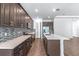 Bright kitchen showcasing dark wood cabinetry, mosaic backsplash, stainless appliances and a large island at 1249 Champions Dr, Daytona Beach, FL 32124
