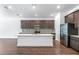 Modern kitchen featuring a large island, stainless steel appliances and sleek dark brown cabinets at 1249 Champions Dr, Daytona Beach, FL 32124