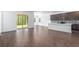 Open-concept living room with wood-look floors, leading to back patio and kitchen at 1249 Champions Dr, Daytona Beach, FL 32124