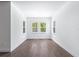Bright, airy living room with sleek floors, white walls, and views of the outdoors from multiple windows at 1249 Champions Dr, Daytona Beach, FL 32124