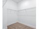 An empty walk-in closet with wire shelving and neutral carpeting offers ample storage space in the home at 1249 Champions Dr, Daytona Beach, FL 32124