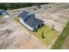 Aerial view of a newly constructed home featuring a lush green lawn and a covered patio for outdoor enjoyment at 1262 Champions Dr, Daytona Beach, FL 32124