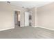 An empty, carpeted bedroom with doorway views to a bathroom and a kitchen at 1262 Champions Dr, Daytona Beach, FL 32124