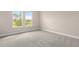 An empty carpeted bedroom with a double window overlooking a landscaped area at 1262 Champions Dr, Daytona Beach, FL 32124