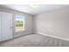 Bright bedroom featuring a window view and neutral-toned carpet at 1262 Champions Dr, Daytona Beach, FL 32124