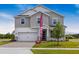Beautiful two-story home with gray siding, stone accents, and a paver driveway at 1262 Champions Dr, Daytona Beach, FL 32124