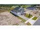 Well-manicured lawn and long brick driveway leading to a two-story, gray home with inviting front porch at 1262 Champions Dr, Daytona Beach, FL 32124