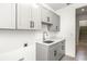 Bright laundry room with modern gray cabinetry, white countertops, and stairs to the next floor at 1262 Champions Dr, Daytona Beach, FL 32124