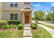 Townhome entrance featuring a covered porch, a landscaped front yard, and a neatly maintained walkway at 12963 Garridan Ave, Windermere, FL 34786