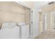 Functional laundry room with modern washer and dryer, next to carpeted hallway at 12963 Garridan Ave, Windermere, FL 34786