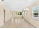 Spacious living room with plenty of windows, tile floors, and a modern chandelier above at 12963 Garridan Ave, Windermere, FL 34786