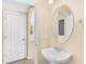 Well-lit powder room with pedestal sink, oval mirror, and tile flooring at 12963 Garridan Ave, Windermere, FL 34786