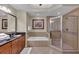 Bright bathroom with a glass enclosed shower, soaking tub, granite countertops and decorative tile at 1354 Centre Court Ridge Dr # 104, Reunion, FL 34747