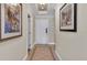 Hallway featuring tile flooring and decorative wall art leads to a welcoming entrance door at 1354 Centre Court Ridge Dr # 104, Reunion, FL 34747