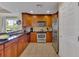 The kitchen features stainless steel appliances, wood cabinetry, and a view of the outside at 1354 Centre Court Ridge Dr # 104, Reunion, FL 34747